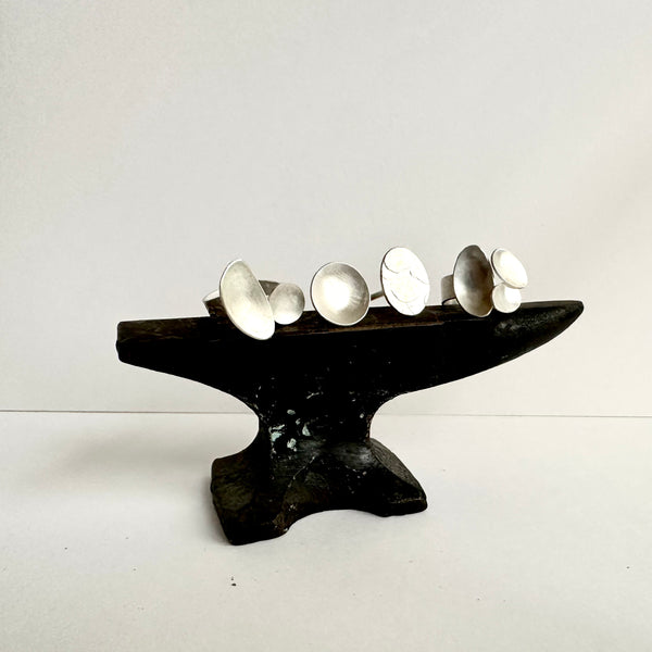 Three open rings sitting on a small black anvil. www.wyckoffsmith.com