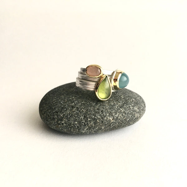 Stack of three gemstone rings on www.wyckoffsmith.com left to right: peach moonstone, green idiocrase (vesuvianite), and aquamarine