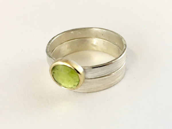Green peridot ring set in 18 ct gold on a textured silver band by www.wyckoffsmith.com