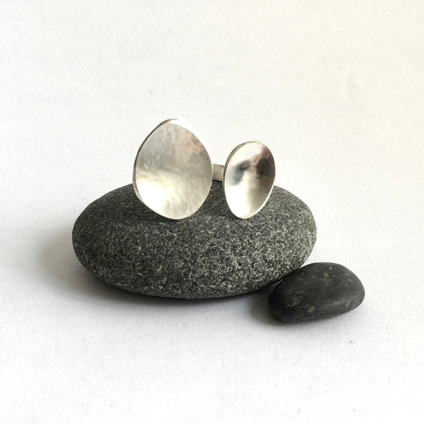 Front view of silver adjustable oval ring sitting on black pebble - style 3 - www.wyckoffsmith.com