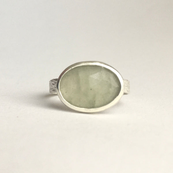 Front view of grey green faceted prehnite gemstone ring set in silver with a textured ring available on www.wyckoffsmith.com