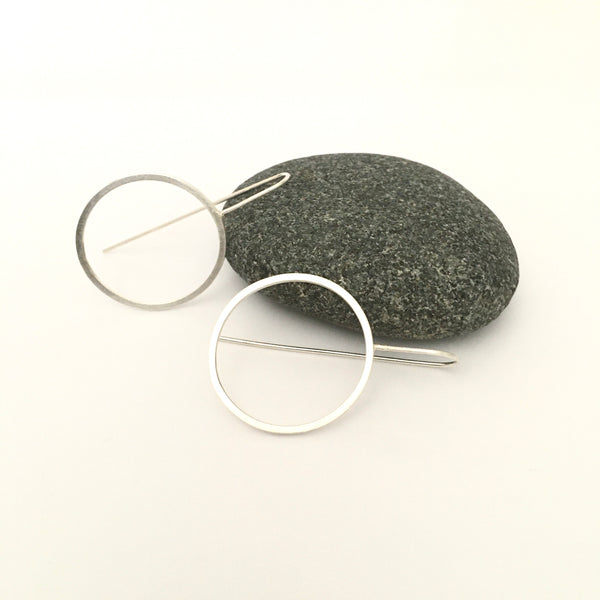 View of light silver circle earrings with grey pebble in background on www.wyckoffsmith.com