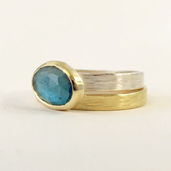 London Blue Topaz ring set in 18 ct gold and silver on top of an 18 ct gold wedding ring by Michele Wyckoff Smith