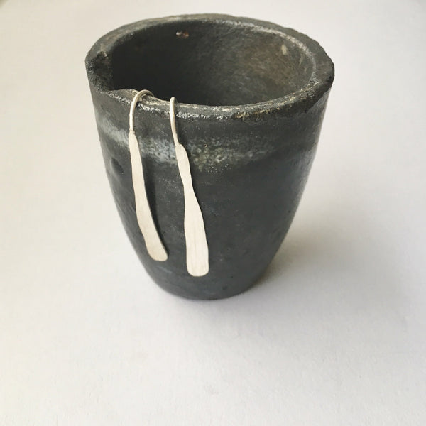 Silver seaweed dangle earrings hanging on the side of a crucible by www.wyckoffsmith.com
