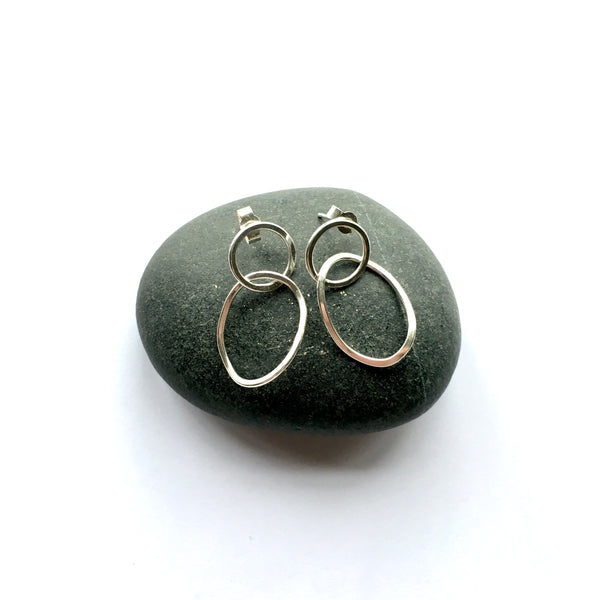 Small silver Twisted Petal Earrings sitting on top of a pebble  on www.wyckoffsmith.com
