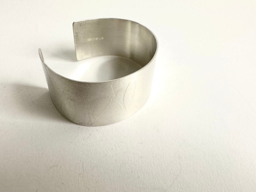 Side view of wide spindle leaf silver cuff - www.wyckoffsmith.com - showing silver hallmark on far side of the cuff