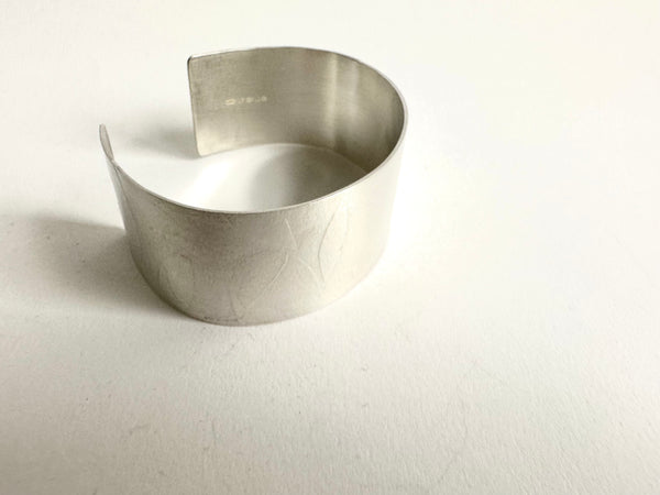 Side view of wide spindle leaf silver cuff - www.wyckoffsmith.com - showing silver hallmark on far side of the cuff