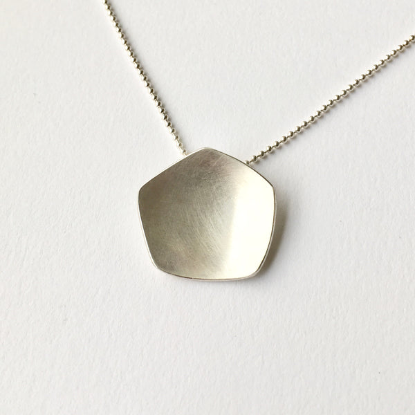 Inspired by the calyx of the poppy head, this abstract silver pendant is by Michele Wyckoff Smith