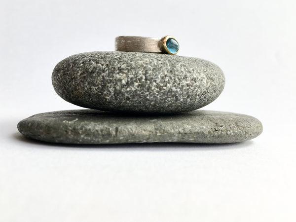 Tourmaline silver and gold stacking ring on top of garnet pebbles by Michele Wyckoff Smith