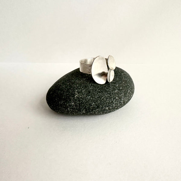 Side view of triple oval ring on a dark stone. Soft hammered texture ring shank. www.wyckoffsmith.com
