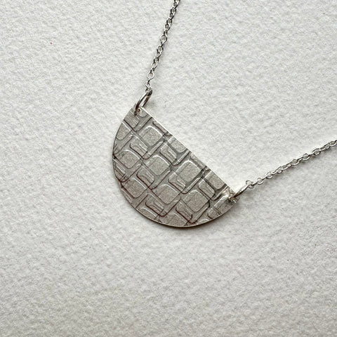 Side view of half moon shaped textured silver pendant with square shapes - Love Letter pendant - www.wyckoffsmith.com - Michele Wyckoff Smith