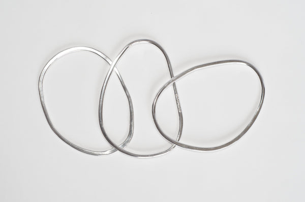 Assorted oval shaped silver bangles by Michele Wyckoff Smith