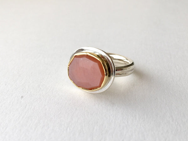 pink peach moonstone platform ring set in 18 ct gold on a silver ring.