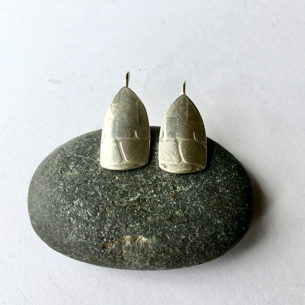 Silver spinnaker earrings with half grid texture on a pebble (option 1) on www.wyckoffsmith.com