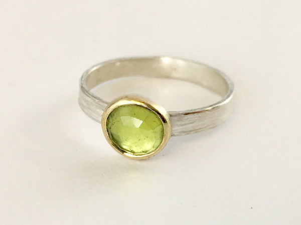 Light green faceted peridot ring set in 18 ct gold on a textured silver band by Michele Wyckoff Smith (UK)