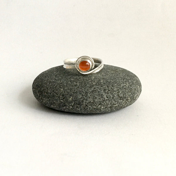 Front view of carnelian and silver ring on pebble - www.wyckoffsmith.com