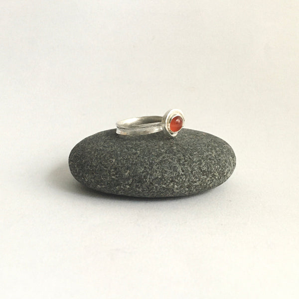 Side view of carnelian and silver ring on pebble - www.wyckoffsmith.com