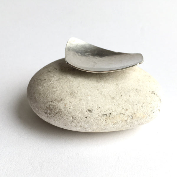 Silver tea caddy spoon on white pebble by Wyckoff Smith Jewellery