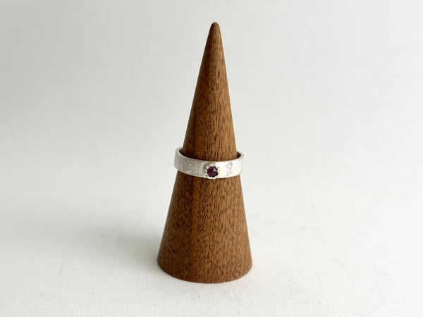 Front view of Tudor set ruby on a 4 mm wide rough hammered ring - www.wyckoffsmith.com