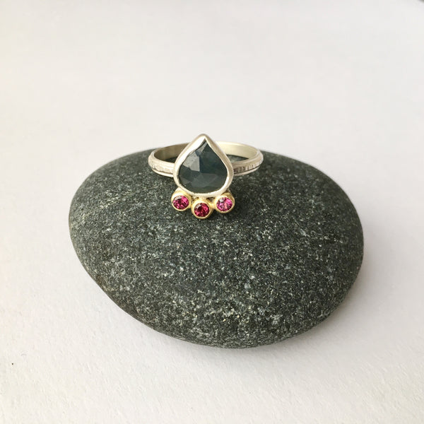 Blue green sapphire and rhodolite garnet ring on a pebble - Wyckoff Smith Jewellery