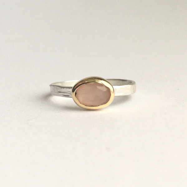 Front view of pale peach moonstone ring set in 18 ct gold with a silver textured ring band on www.wyckoffsmith.com