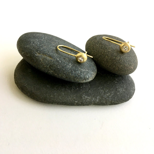Diamond and 18 ct recycled gold earrings sitting on pebbles - www.wyckoffsmith.com - Michele Wyckoff Smith
