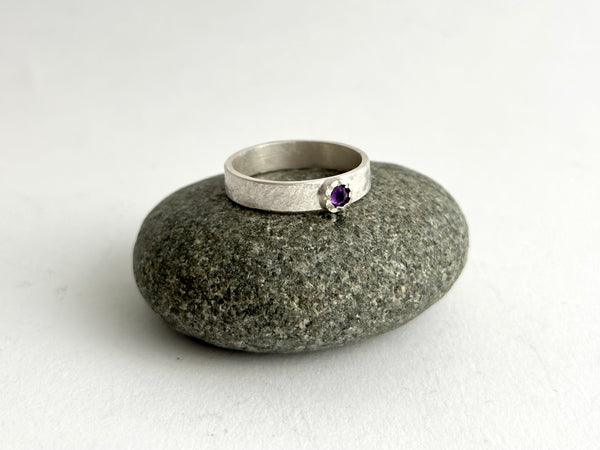 Inverted faceted amethyst with a hammered tudor setting and rough hammered band on a pebble - www.wyckoffsmith.com