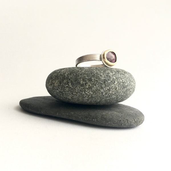 Side view of pink tourmaline ring on two pebbles on www.wyckoffsmith.com silver and gold jewellery