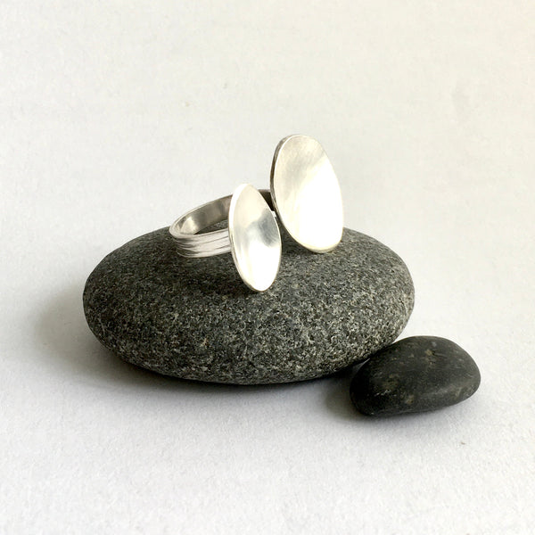 Adjustable silver oval ring sitting on black pebbles - style 3 - www.wyckoffsmith.com