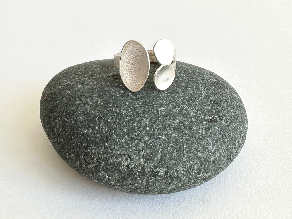Adjustable textured oval ring on a pebble - www.wyckoffsmith.com