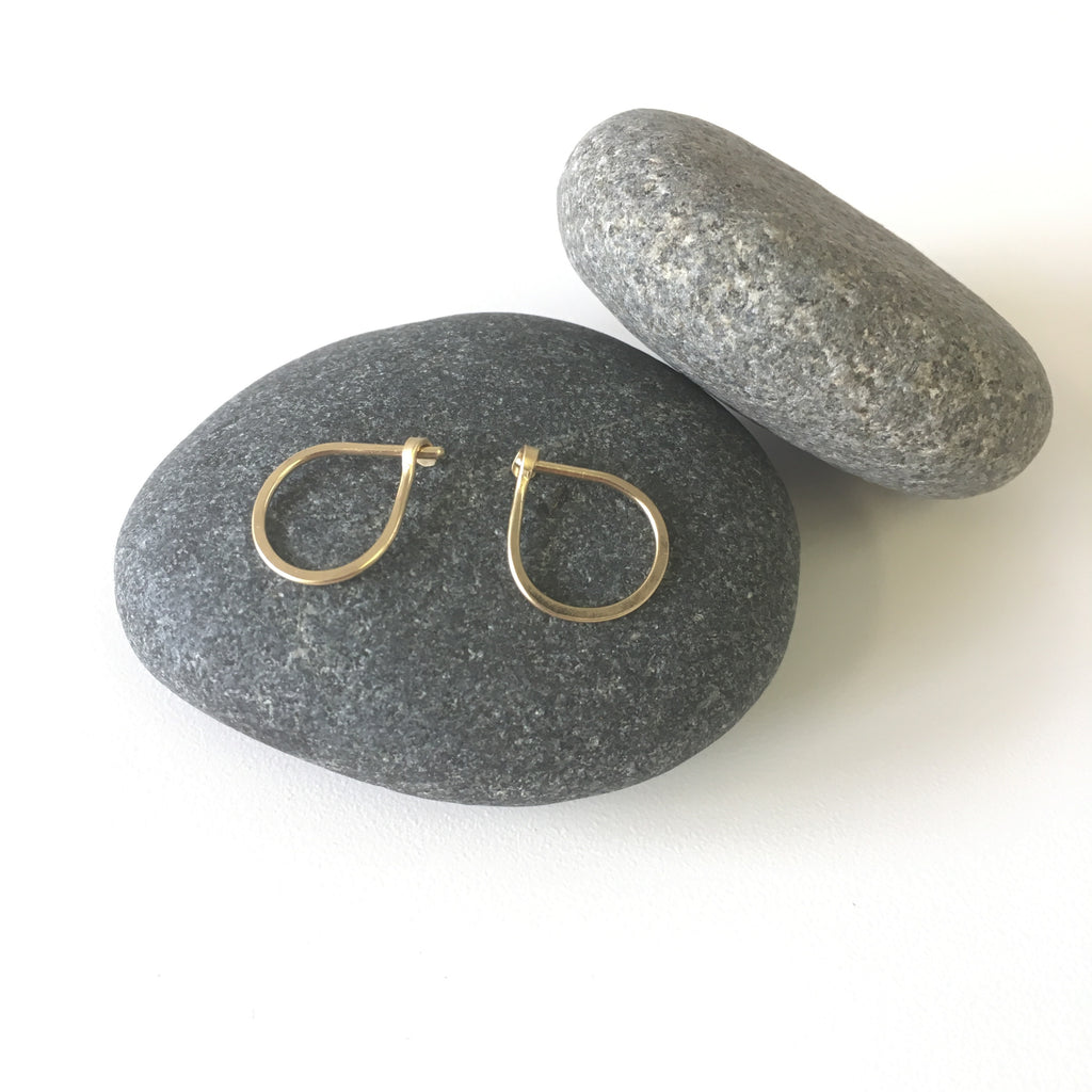 Two hand forged 18 ct gold hoop earrings on a black stone - Wyckoff Smith Jewellery
