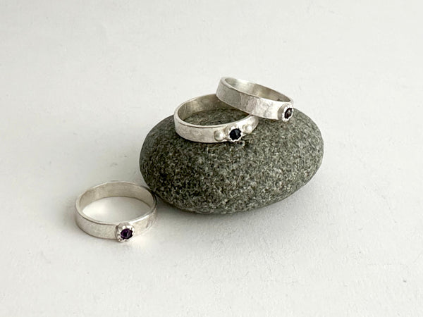 Assortment of inverted gemstones in a Tudor Setting on a pebble - 4 mm wide rough hammered texture silver ring - www.wyckoffsmith.com