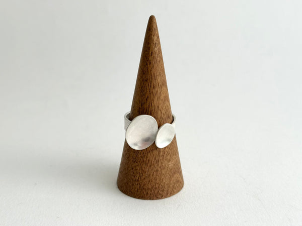 Open and adjustable ring with matte ovals on a wooden ring stand - www.wyckoffsmith.com