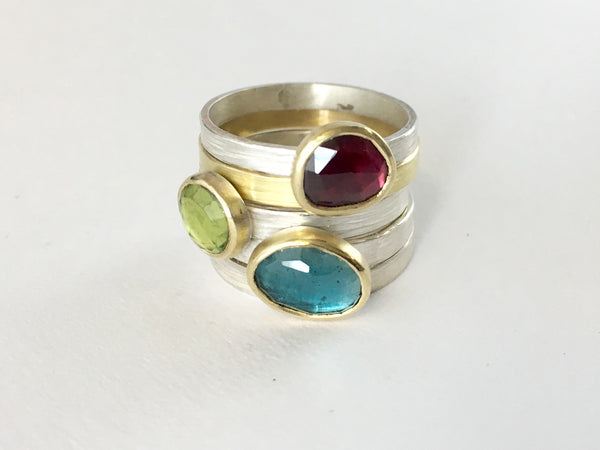 Stacking gemstone rings set in 18 ct gold with textured silver or gold bands on www.wyckoffsmith.com: garnet, peridot and London blue topaz rings some separately.