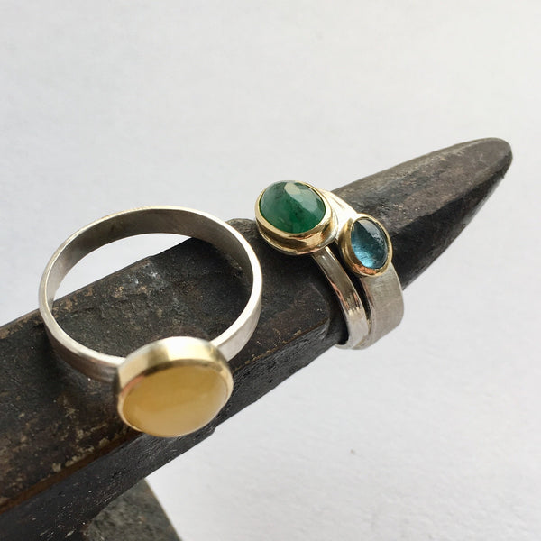 Gemstone silver and gold stacking rings on mini anvil: amber, emerald and tourmaline by Wyckoff Smith Jewellery